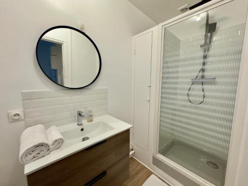 une salle de bain avec un lavabo, une douche et un miroir dans l'établissement Spacieux Appartement 3 chambres Au Pied De La Gare, à Amiens