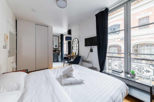 une chambre avec un lit blanc et une grande fenêtre dans l'établissement Appartement service - Vue sur le Musee - Paris 5 - FLAT-GUEST, à Paris