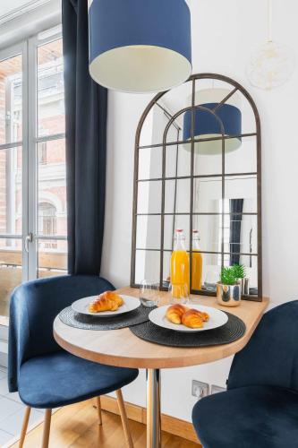- une table à manger avec deux assiettes de nourriture dans l'établissement Appartement service - Vue sur le Musee - Paris 5 - FLAT-GUEST, à Paris