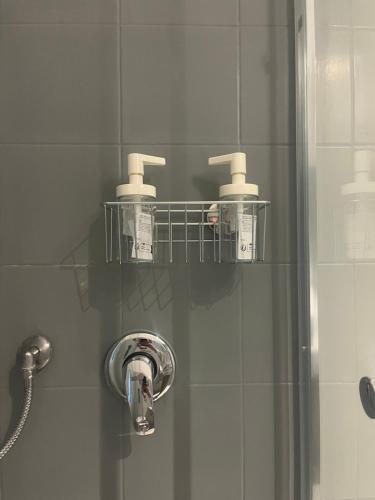 a shower with three rolls ofodorizers and a shelf in a bathroom at Cozy Historical Nest in Naples
