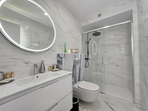 a white bathroom with a shower and a toilet at Mareverde Dream in Costa de Adeje