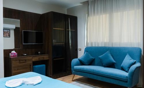 a blue couch in a room with a bed and a television at Mirage pyramids view hotel in Cairo