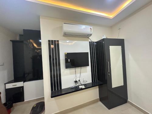 Una televisión o centro de entretenimiento en MahaDeepam Residency