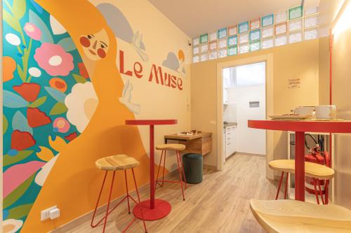 a room with tables and stools and a mural at Le Muse Suites in Rome