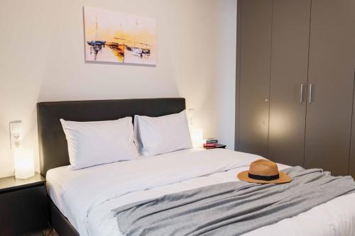 a bed with a hat sitting on top of it at Spacious seaside flat at alimos in Athens