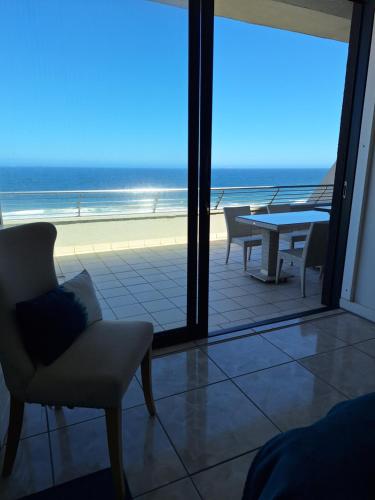 a room with a table and chairs and a view of the ocean at 30 Degrees in Umdloti