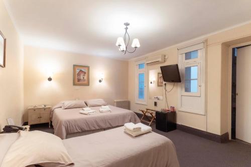 a hotel room with two beds and a tv at Hotel Colonial Salta in Salta