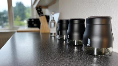 two black coffee cups sitting on top of a counter at Sleeps 8 3 BED Parking NEC JLR NIA Airport in Birmingham
