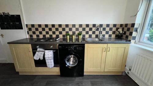 a kitchen with a washing machine and a sink at Sleeps 8 3 BED Parking NEC JLR NIA Airport in Birmingham