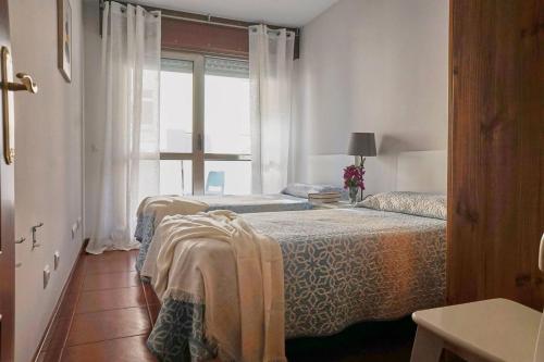 twee bedden in een kamer met een raam bij FGDR342E La Playona in San Vicente de la Barquera