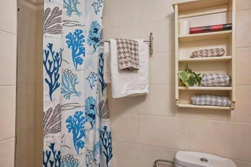 een badkamer met een douchegordijn en een toilet bij FGDR342E La Playona in San Vicente de la Barquera