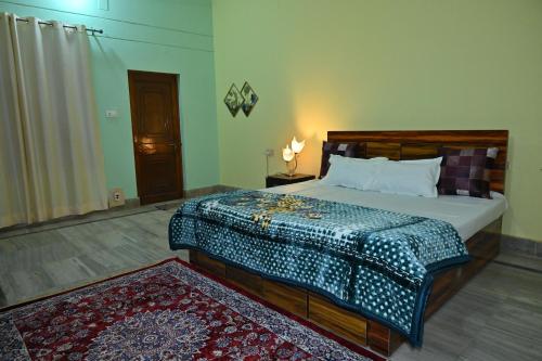 a bedroom with a large bed and a rug at Jai Villa homestay in Prayagraj