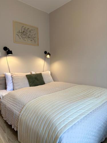 a bedroom with a large white bed with two lamps at APARTAMENTY LAVENDERIA z widokiem na Górę Parkową, blisko centrum in Kudowa-Zdrój