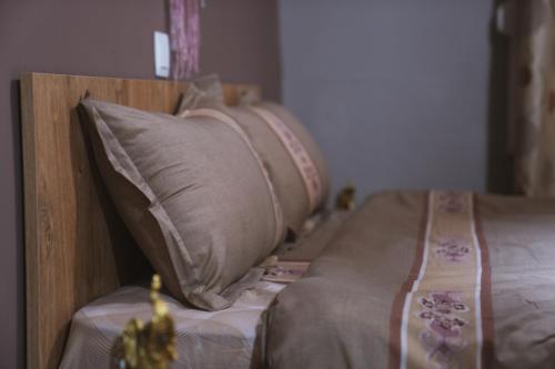 a bed with a wooden head board with pillows at Villa Katerina in Polykárpion