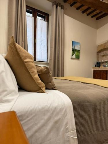 a bedroom with a bed and a window at PienzaLettings Studio & Room in Pienza