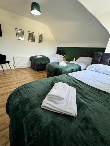 a hotel room with three beds with towels on them at Sleeps 8 3 BED Parking NEC JLR NIA Airport in Birmingham