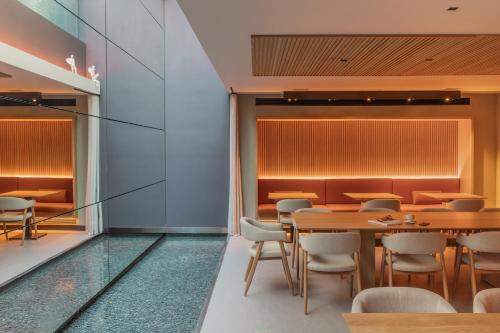 a dining room with wooden tables and chairs at Hotel Arconte, Adults Only in Barcelona