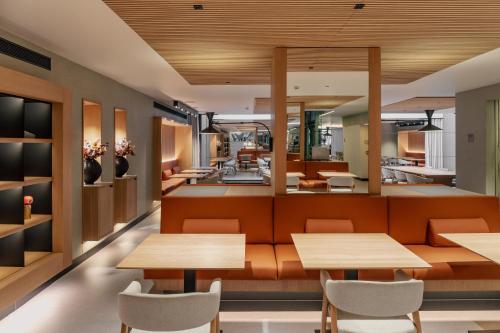 a restaurant with wooden tables and chairs at Hotel Arconte, Adults Only in Barcelona