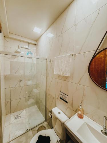 a bathroom with a shower and a toilet and a sink at Espaços Cardoso, AURORA - luz e leveza in Igrejinha