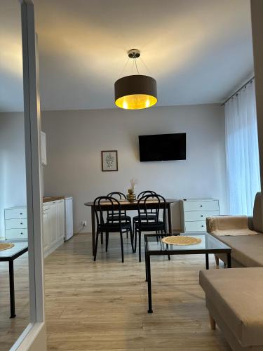a living room with a table and a dining room at APARTAMENTY LAVENDERIA z widokiem na Górę Parkową, blisko centrum in Kudowa-Zdrój