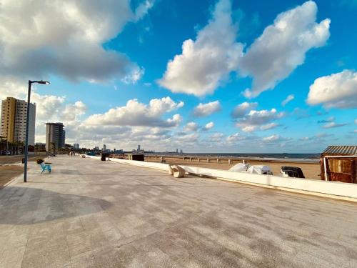 a boardwalk on a beach with a blue sky and clouds at Vista al mar, Mini alberca y roof garden PRIVADO! in Boca del Río