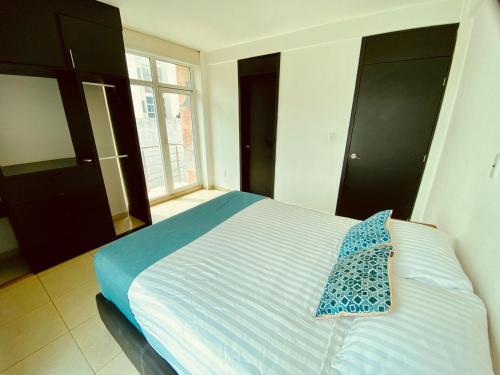 a bedroom with a bed with a blue pillow on it at Vista al mar, Mini alberca y roof garden PRIVADO! in Boca del Río