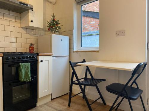 a kitchen with a white refrigerator and a table and two chairs at PROMO Modern 1-bedroom Flat near CrokePark and CityCentre in Dublin