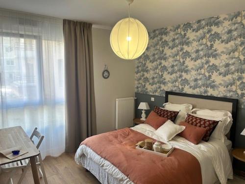 Un dormitorio con una cama grande con una ventana grande. en Résidence Montana Reims Tinqueux, en Tinqueux