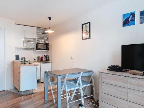 une cuisine et une salle à manger avec une table et une télévision dans l'établissement Appartement skieurs, accès direct pistes, balcon sud, proche remontées - FR-1-518-109, à Val dʼIsère