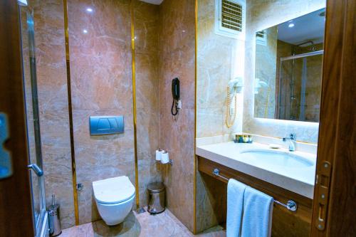 a bathroom with a sink and a toilet and a mirror at Royal Hotel Inegol in Inegol