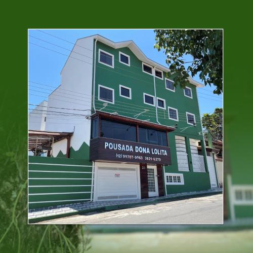 a green building with a sign that reads pueblula downounge at Pousada Dona Lolita in Cachoeira Paulista