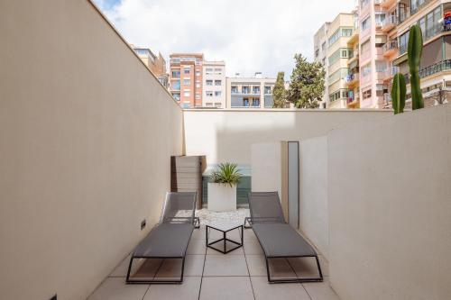 a balcony with benches and a potted plant on a building at Hotel Arconte, Adults Only in Barcelona