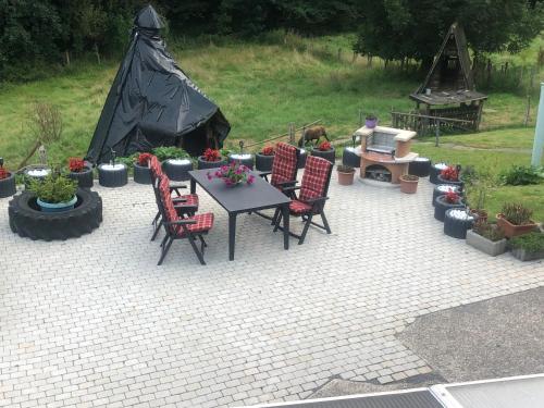 a patio with a table and chairs and a tent at Ferienwohnung Wolf in Reichshof 