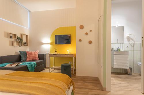 a room with a bed and a couch and a tv at Le Muse Suites in Rome