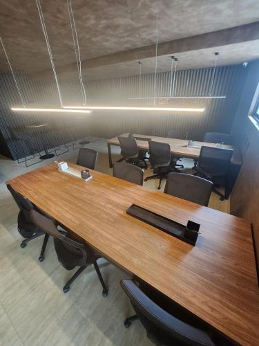 a conference room with a large wooden table and chairs at Get By Side in João Pessoa