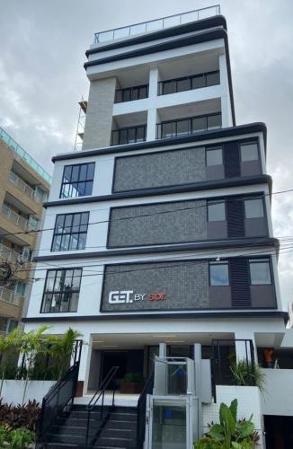a tall building with stairs in front of it at Get By Side in João Pessoa