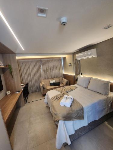 a bedroom with a large bed and a couch at Get By Side in João Pessoa