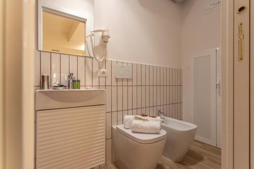a bathroom with a toilet and a sink and a tub at Le Muse Suites in Rome
