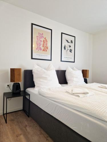 a bedroom with a large white bed with a side table at ARGENTA Living 129 in Künzell