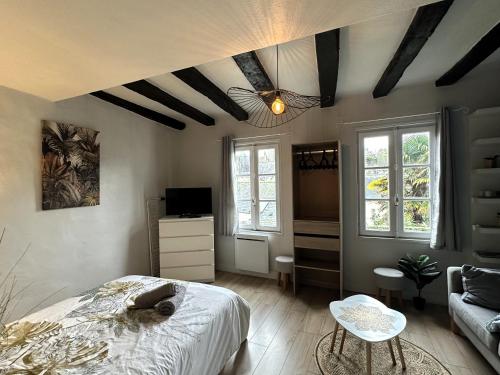 - une chambre avec un lit, un canapé et des fenêtres dans l'établissement Côté Cathédrale - Grand studio Rue du Salé - Centre Historique, à Quimper