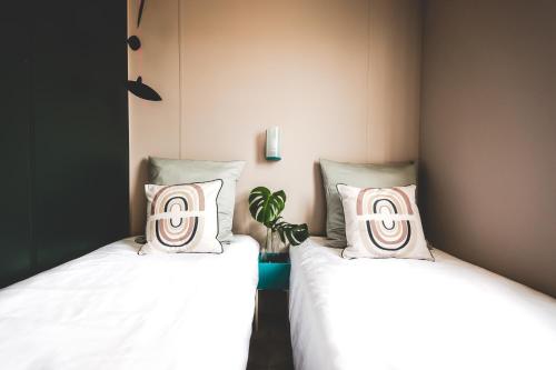 two beds sitting next to each other in a room at DS One Vacances, Prairies de la Mer in Grimaud