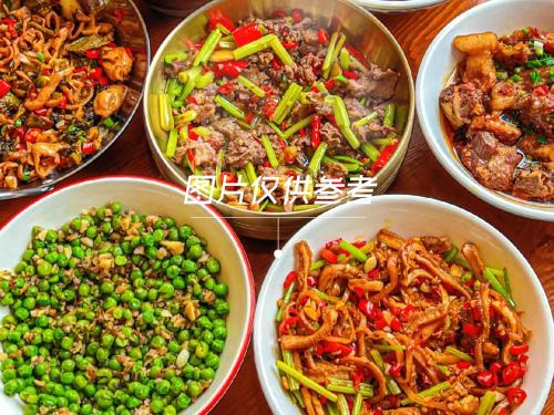 a table topped with bowls of different types of food at Avatar Hilltop Manor B&B in Zhangjiajie