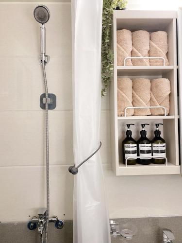 a shower with a shower curtain in a bathroom at Gangseo House in Seoul