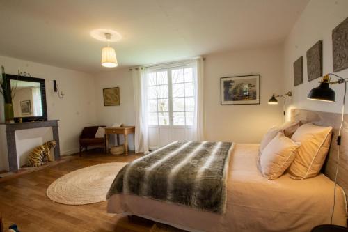 une chambre avec un grand lit et une cheminée dans l'établissement L' ostal de maite, à Annesse-et-Beaulieu