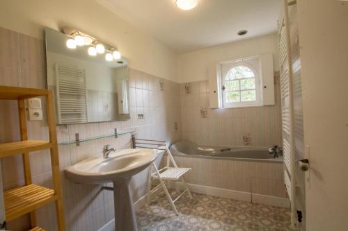 une salle de bains avec lavabo et baignoire dans l'établissement L' ostal de maite, à Annesse-et-Beaulieu