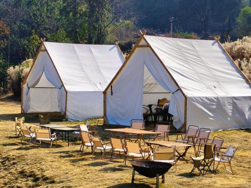 a group of tables and chairs in front of a tent at Avatar Hilltop Manor B&B in Zhangjiajie