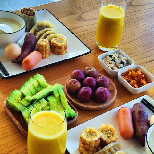 a wooden table topped with plates of food and drinks at Avatar Hilltop Manor B&B in Zhangjiajie