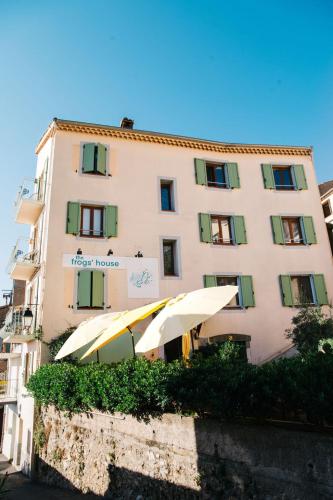 un grand bâtiment avec des parasols en face de celui-ci dans l'établissement The frogs' house - Yoga Retreat, à Saint-Jeannet