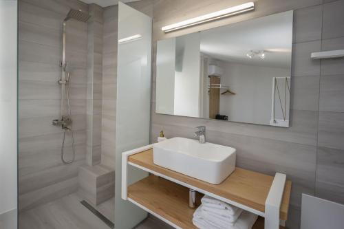 a bathroom with a white sink and a mirror at Hermagio Villa Mary by Estia in Malia