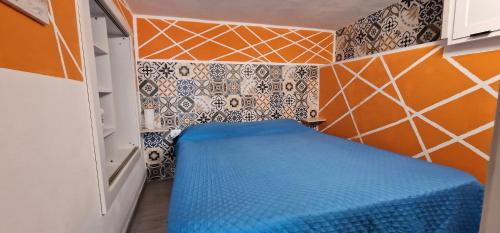a small room with a blue bed in the corner at Balcone sul Golfo di Castellammare in Alcamo